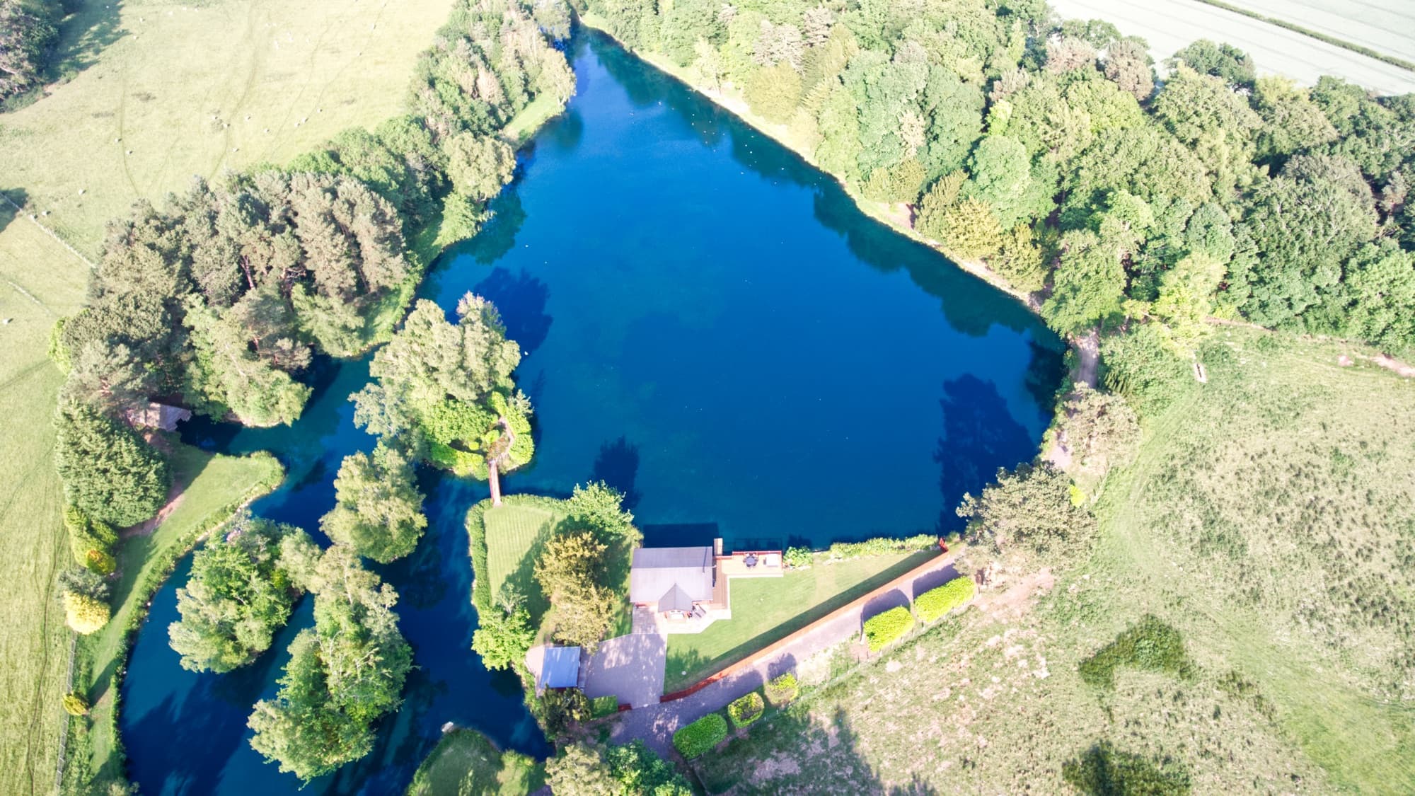 The whole five-acre lake from the air — the lodge the only building on its shore