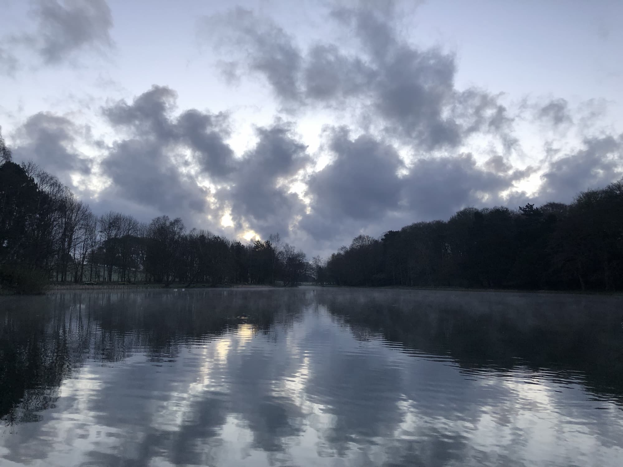 Dawn breaking over the still lake