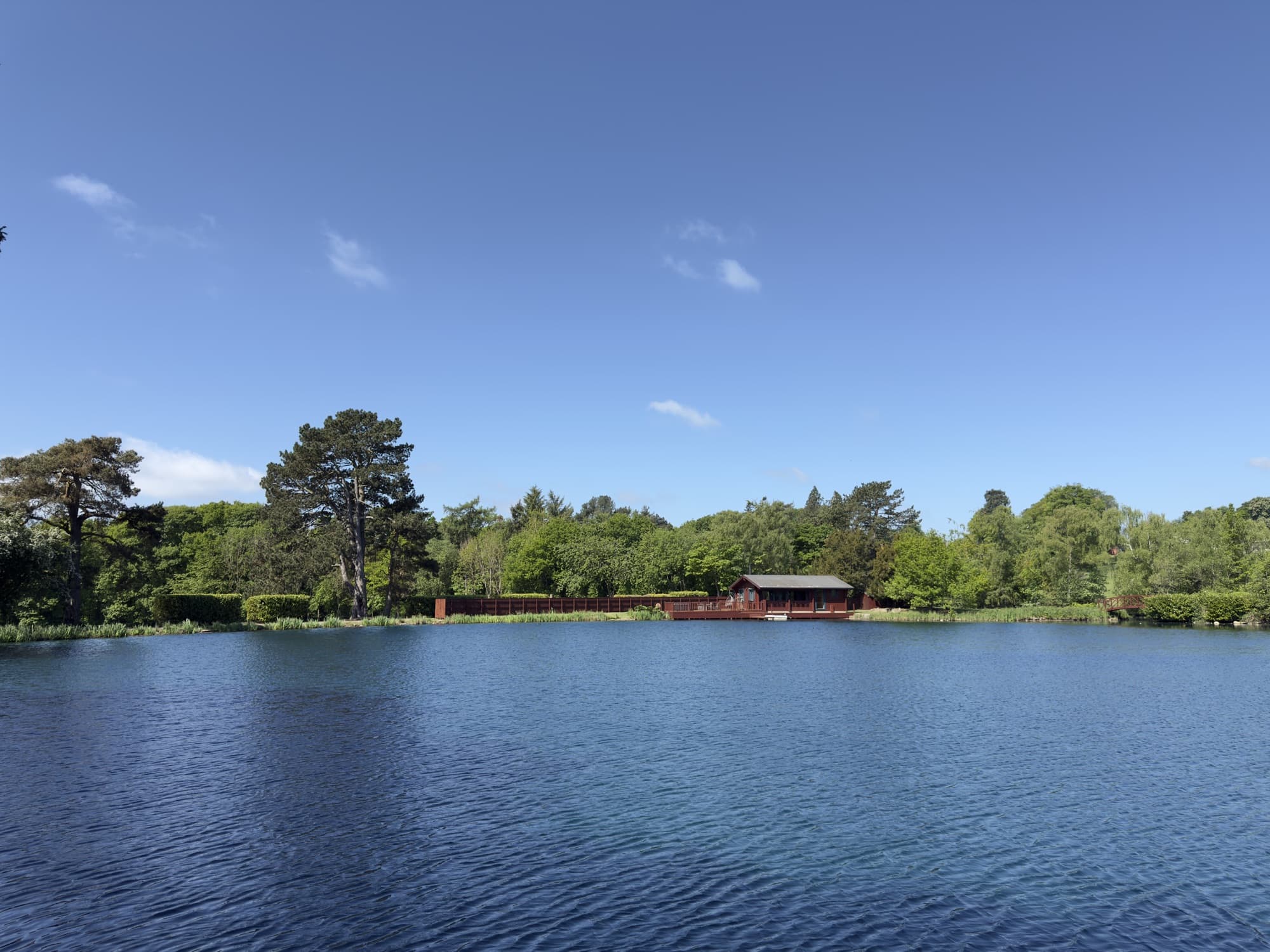 The lodge across the lake under a clear spring sky